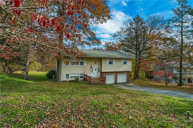 bi-level home featuring an attached garage, aphalt driveway, and a front yard