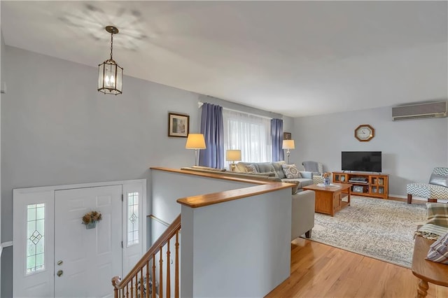 entrance foyer with a wall unit AC and light wood-style flooring