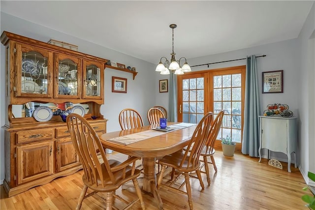 dining room featuring light wood finished floors and a notable chandelier