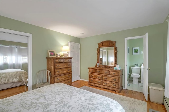 bedroom featuring light wood-style floors and ensuite bath