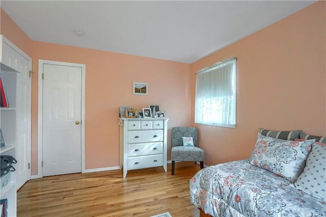 bedroom with light wood-type flooring and baseboards