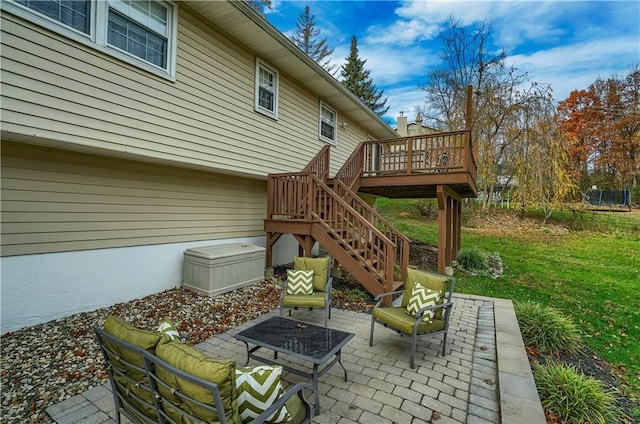 view of patio / terrace with a trampoline, stairway, and a deck