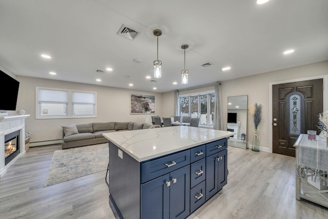 kitchen with a baseboard radiator, visible vents, light wood-style flooring, and a glass covered fireplace