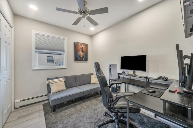 home office featuring a baseboard heating unit, ceiling fan, light wood finished floors, and recessed lighting