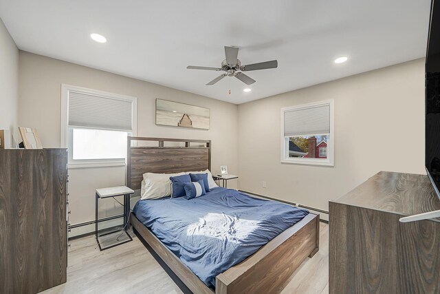 bedroom with a baseboard heating unit, recessed lighting, light wood-style flooring, and a ceiling fan