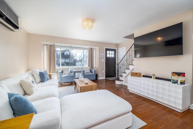 living area featuring dark wood-style floors, radiator, a wall mounted AC, baseboards, and stairs