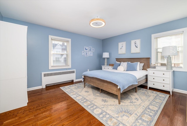 bedroom featuring radiator, baseboards, and wood finished floors