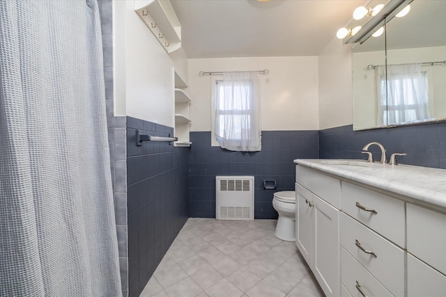 bathroom featuring curtained shower, radiator heating unit, toilet, vanity, and tile patterned floors