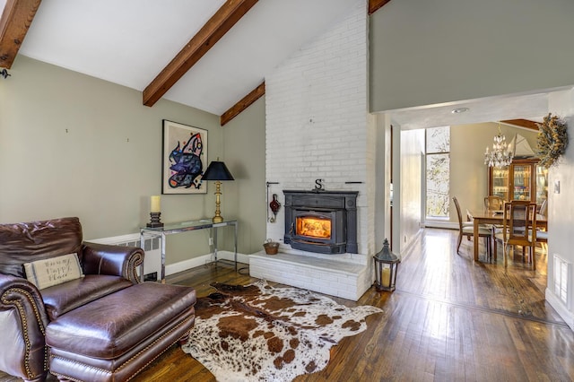 living area featuring a fireplace, baseboards, beamed ceiling, and hardwood / wood-style floors