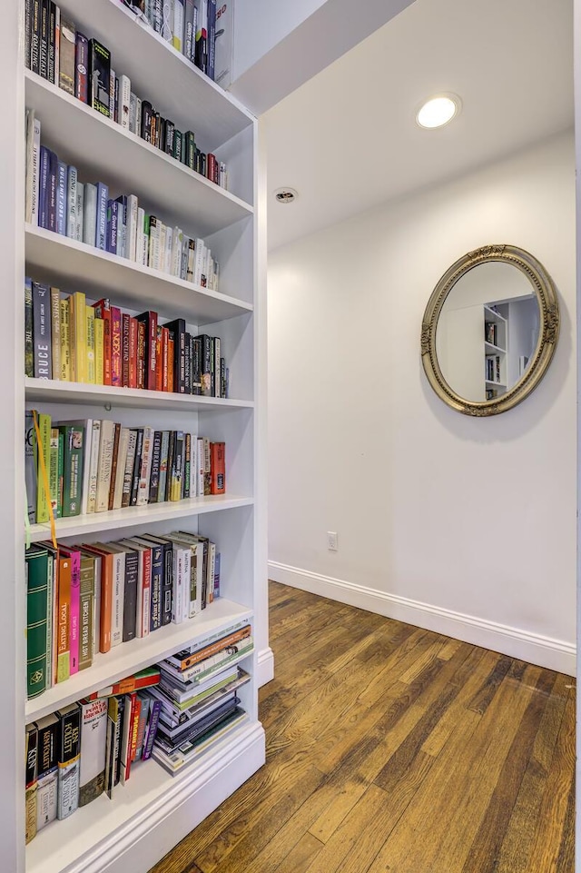 corridor featuring recessed lighting, wood finished floors, and baseboards