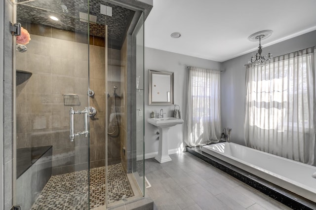 full bath featuring an inviting chandelier, a shower stall, and baseboards