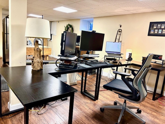 office featuring a drop ceiling, wood finished floors, and baseboards