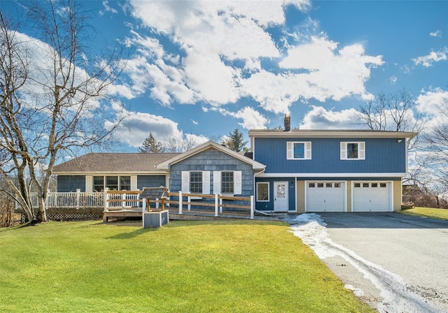 view of front facade with a front lawn, a garage, a chimney, and aphalt driveway