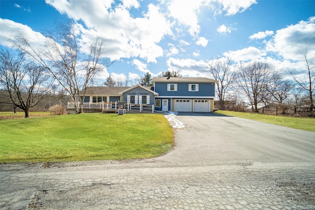 view of front of home featuring a deck, a front yard, a garage, and driveway