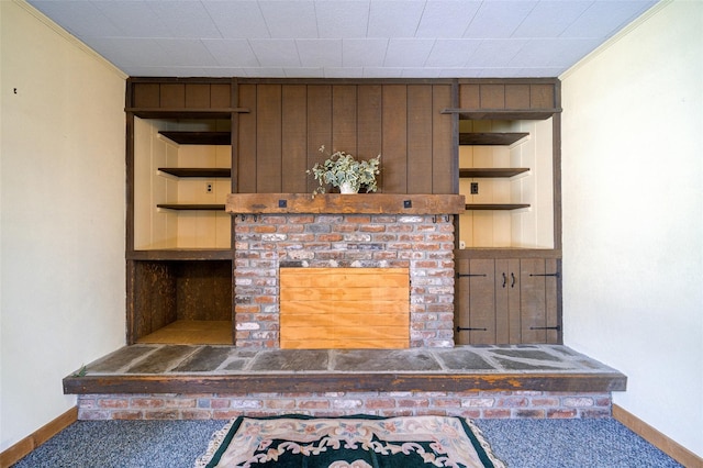 unfurnished living room featuring built in shelves, baseboards, and carpet floors