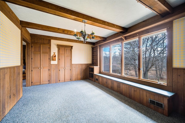 unfurnished sunroom with visible vents, beam ceiling, and a notable chandelier