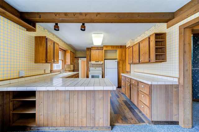 kitchen with open shelves, wallpapered walls, a sink, and freestanding refrigerator