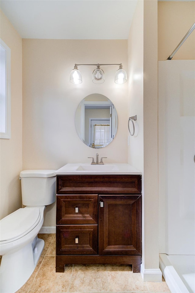 bathroom featuring toilet, tile patterned flooring, baseboards, walk in shower, and vanity