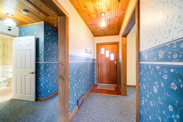 corridor with wallpapered walls, carpet flooring, wood ceiling, and a wainscoted wall