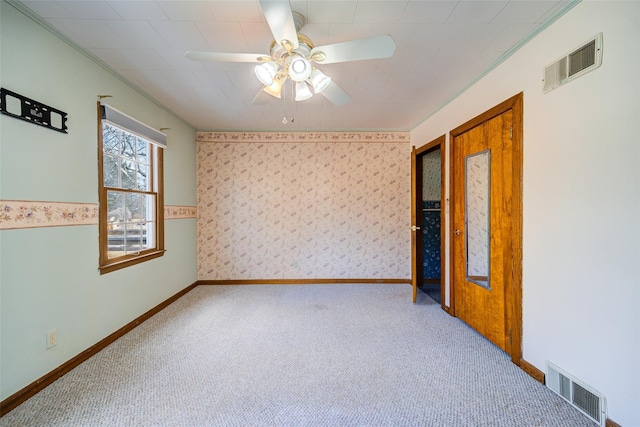 unfurnished room featuring visible vents, carpet, ceiling fan, and wallpapered walls