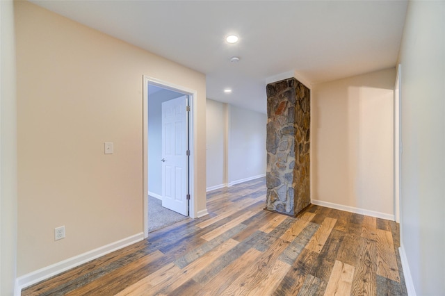 empty room with recessed lighting, baseboards, and wood finished floors