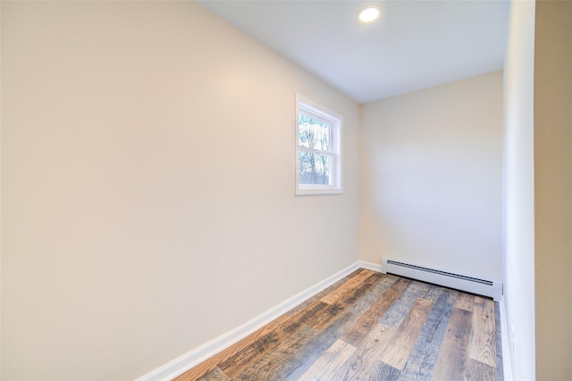 spare room with recessed lighting, wood finished floors, baseboards, and a baseboard radiator