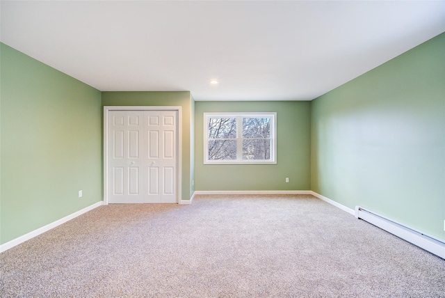 unfurnished bedroom featuring a closet, carpet floors, baseboards, and a baseboard radiator