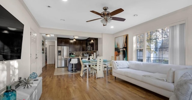 living room with a ceiling fan, recessed lighting, and light wood finished floors