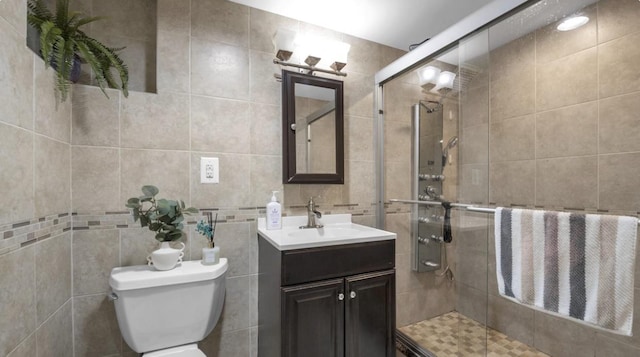 bathroom featuring tile walls, decorative backsplash, toilet, a stall shower, and vanity