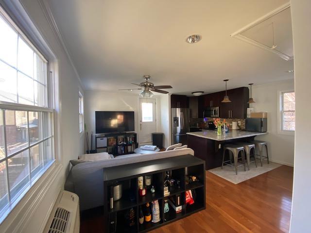 living room with ceiling fan and wood finished floors