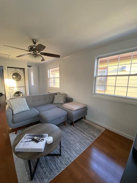 living area featuring ceiling fan, ornamental molding, wood finished floors, and baseboards