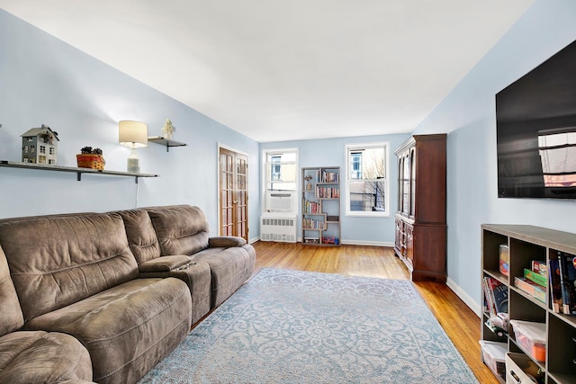 living room with baseboards, wood finished floors, and radiator