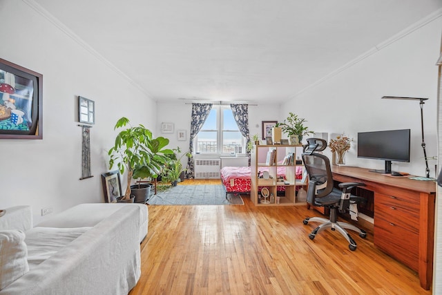 office area with ornamental molding, radiator heating unit, and wood-type flooring