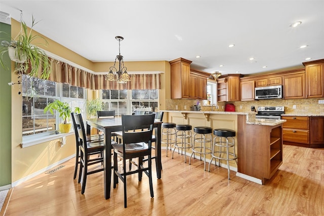 kitchen with stainless steel appliances, visible vents, decorative backsplash, open shelves, and brown cabinetry