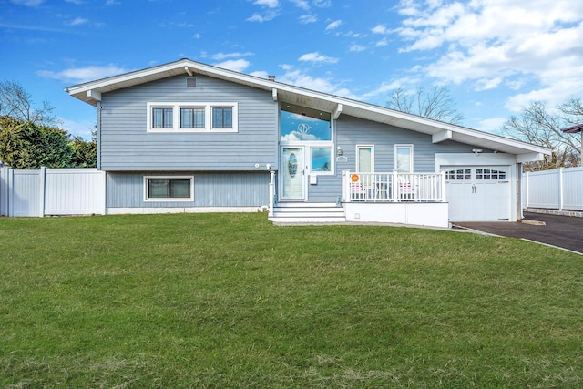 view of front of home featuring a garage, fence, aphalt driveway, and a front yard