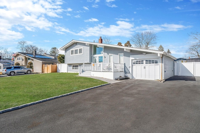 view of front of home with a garage, driveway, a front yard, and fence