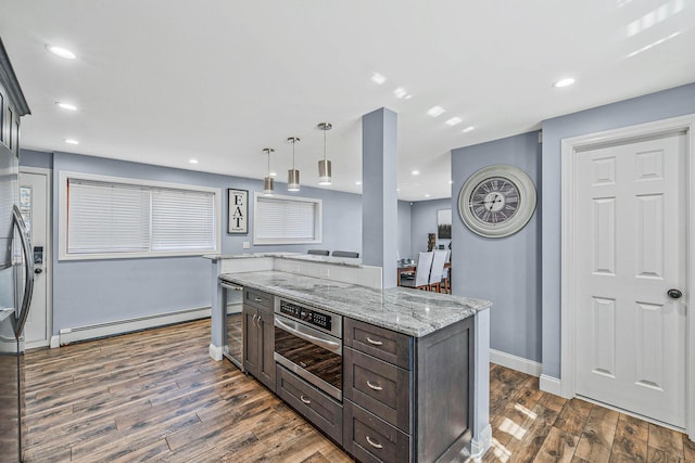 kitchen with a baseboard radiator, dark wood-type flooring, a kitchen island, dark brown cabinetry, and oven