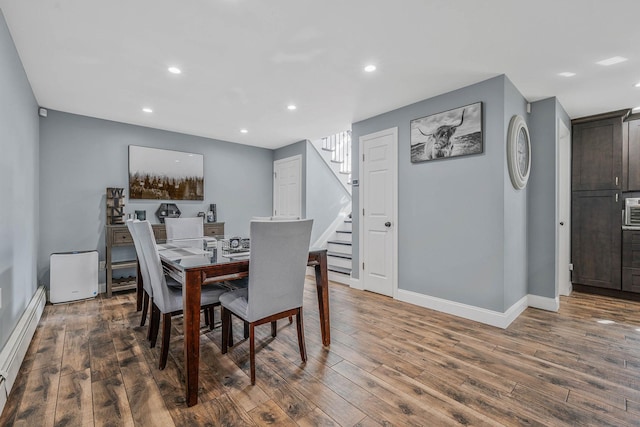 dining area with a baseboard radiator, recessed lighting, stairway, wood finished floors, and baseboards