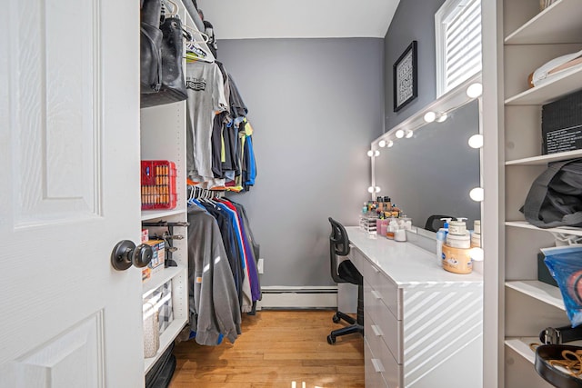 spacious closet featuring a baseboard radiator and wood finished floors