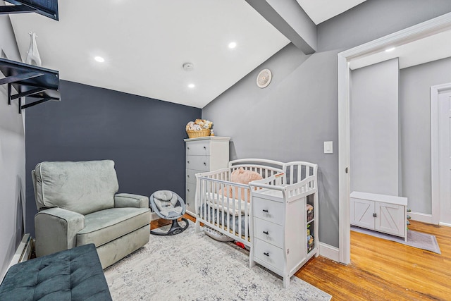 bedroom with vaulted ceiling with beams, recessed lighting, wood finished floors, baseboards, and a crib