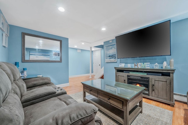 living area featuring light wood-style floors, recessed lighting, a warm lit fireplace, and baseboards