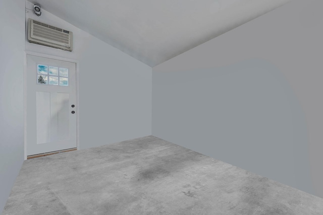 interior space featuring lofted ceiling and an AC wall unit