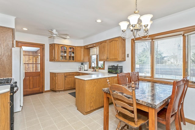 kitchen with stainless steel gas range oven, brown cabinetry, a peninsula, light countertops, and crown molding