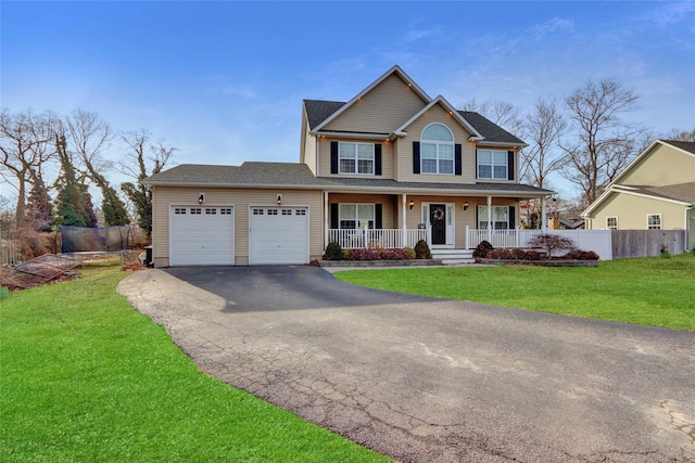 view of front of home featuring a porch, an attached garage, a front yard, fence, and driveway