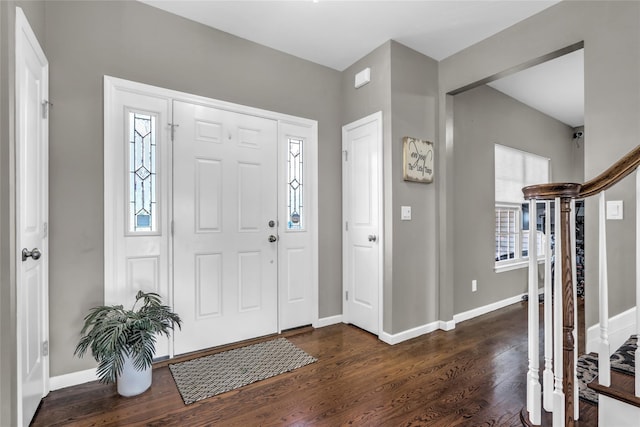 entryway with dark wood-style floors, stairway, and baseboards