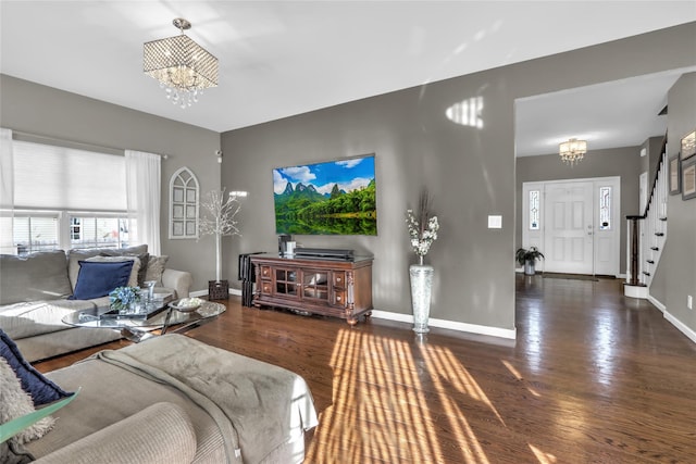 living room with stairway, a notable chandelier, and wood finished floors