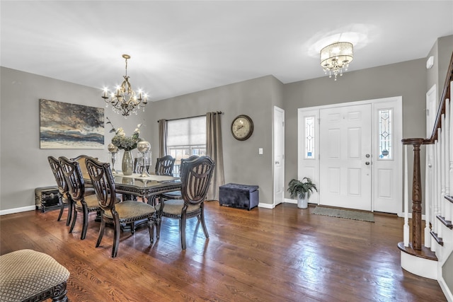 dining area with baseboards, hardwood / wood-style floors, and an inviting chandelier