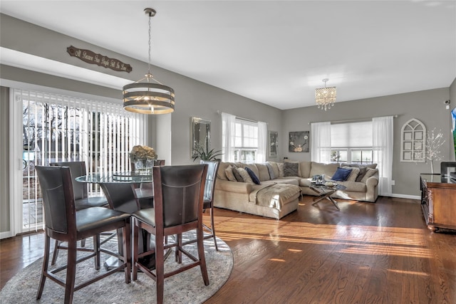 dining room featuring a chandelier, baseboards, and wood finished floors