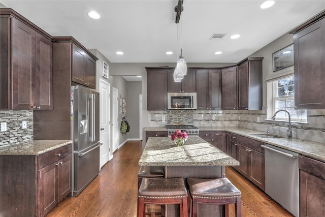 kitchen with dark wood-style floors, high end appliances, a sink, and visible vents