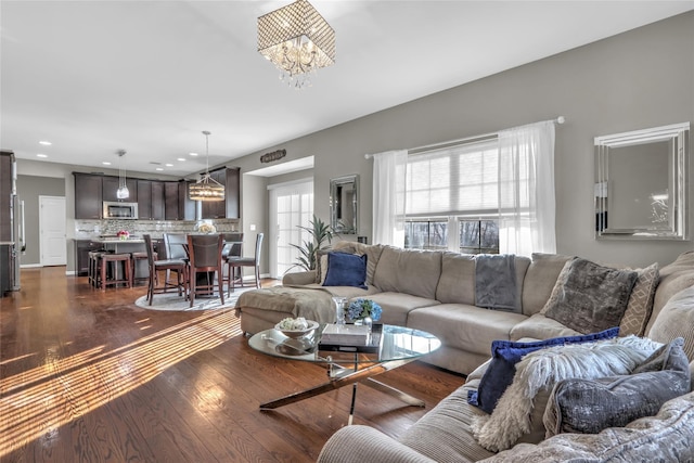 living area featuring dark wood-style floors, recessed lighting, and an inviting chandelier